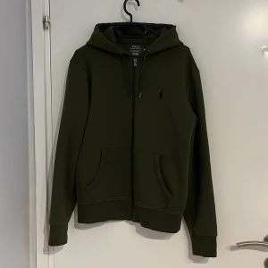 Ralph Lauren kofta - Säljer denna mycket fina Ralph lauren kofta i nyskick varan är så gott som ny bara att ena metallsaken på en av snörerna har gått av annars är koftan helt ny materialet är mjukt och skönt. Storlek S nypris 2195kr men säljer för 1000kr men kan sänkas 