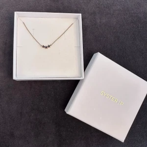 Halsband Syster P - Guldigt halsband från Syster P med tre små stjärnor. Varan är i gott skick och asken medföljer.