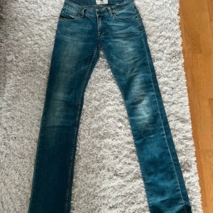 Blå jeans från True Religion - Säljer ett par snygga blå jeans från True Religion. De har en klassisk femficksdesign och en cool tvätt som ger dem en avslappnad look. Perfekta för både vardag och fest!
