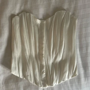 Vit Zara korsett topp - Oanvänd korsett topp från Zara, passar storlek S också! Glansigt fint material och sitter på bekvämt och bra! Bra skick! 