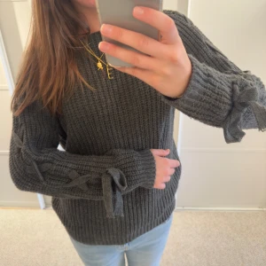 Stickad tröja med knytning på ärmarna - Unik tröja i grön grå färg i bra skick💕 står ingen storlek men skulle säga att den är strl 38 (S-M) köp gärna genom köp nu💖