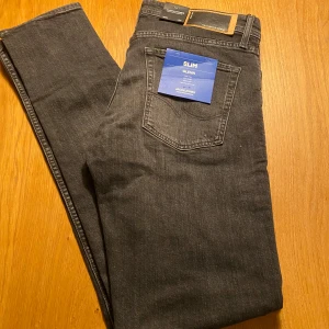 Slim fit jeans från Jack & Jones - Säljer ett par snygga grå slim fit jeans från Jack & Jones i modellen Glenn. De har en låg midja och är tighta vid benen med slitna detaljer! 🖤