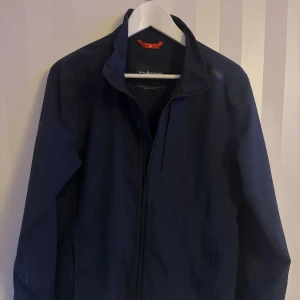  Sail Racing Jacka - Säljer en stilren mörkblå jacka från Sail Racing i storlek Small! Nyskick, inte alls mycket använd!Kontakta mig för fler frågor!