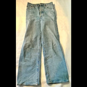 Levi's Ribcage Straight Jeans - Säljer ett par snygga Levi's Ribcage Straight jeans i ljusblå denim. De har en klassisk straight fit med mid waist. Bra skick.