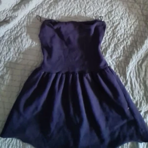 Mörklila axelbandslös tubtopp  - Säljer en superfin mörklila axelbandslös tub topp. Perfekt för festliga tillfällen! Den har en söt och enkel design med en smickrande passform. Klänningen är i bra skick och redo för nya äventyr. Passar perfekt till både sommar och vår.