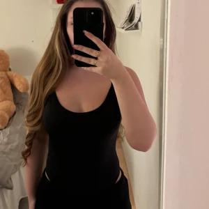 Svart ärmlös bodysuit - Säljer en stilren svart bodysuit med smala axelband. Perfekt för både vardag och fest! Den är i ett stretchigt material som ger en tight passform. 