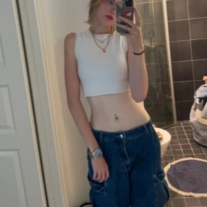 Vit croppad linnetopp från Zara - Säljer en stilren vit croppad linnetopp från Zara. Perfekt för varma dagar och enkel att matcha med olika outfits. Toppen är ärmlös och har en ribbad struktur som ger en snygg passform. Använd relativt mycket men fortfarande i mycket gott skick :)