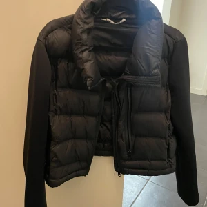 Svart pufferjacka -  en snygg svart pufferjacka i mycket bra skick. Perfekt för exempelvis sena sommarkvällar håller dig varm och stilren