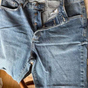 Blå jeans med slitningar från Diesel - Säljer ett par snygga blå jeans från Diesel i bra skick. De har coola slitningar på benen och en knappgylf. Perfekta för en avslappnad stil. Passar till både vardag och fest!