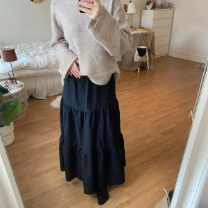 Svart långkjol - Snygg svart långkjol med flera lager som ger en fin volym. Kjolen har en avslappnad passform och är perfekt för en stilren look. Den är enkel att matcha med olika toppar och accessoarer🖤