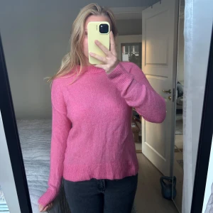 Rosa stickad tröja - Säljer en mysig rosa stickad mohair tröja med långa ärmar och ribbstickade muddar. Perfekt för kyligare dagar och ger en färgklick till garderoben. Passar bra till jeans eller kjol.