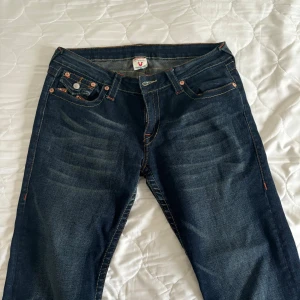 Mörkblå jeans med broderade bakfickor - Säljer ett par snygga mörkblå jeans i bra skick. De har coola broderade detaljer på bakfickorna och en klassisk femficksdesign. Perfekta för både vardag och fest! 🕺