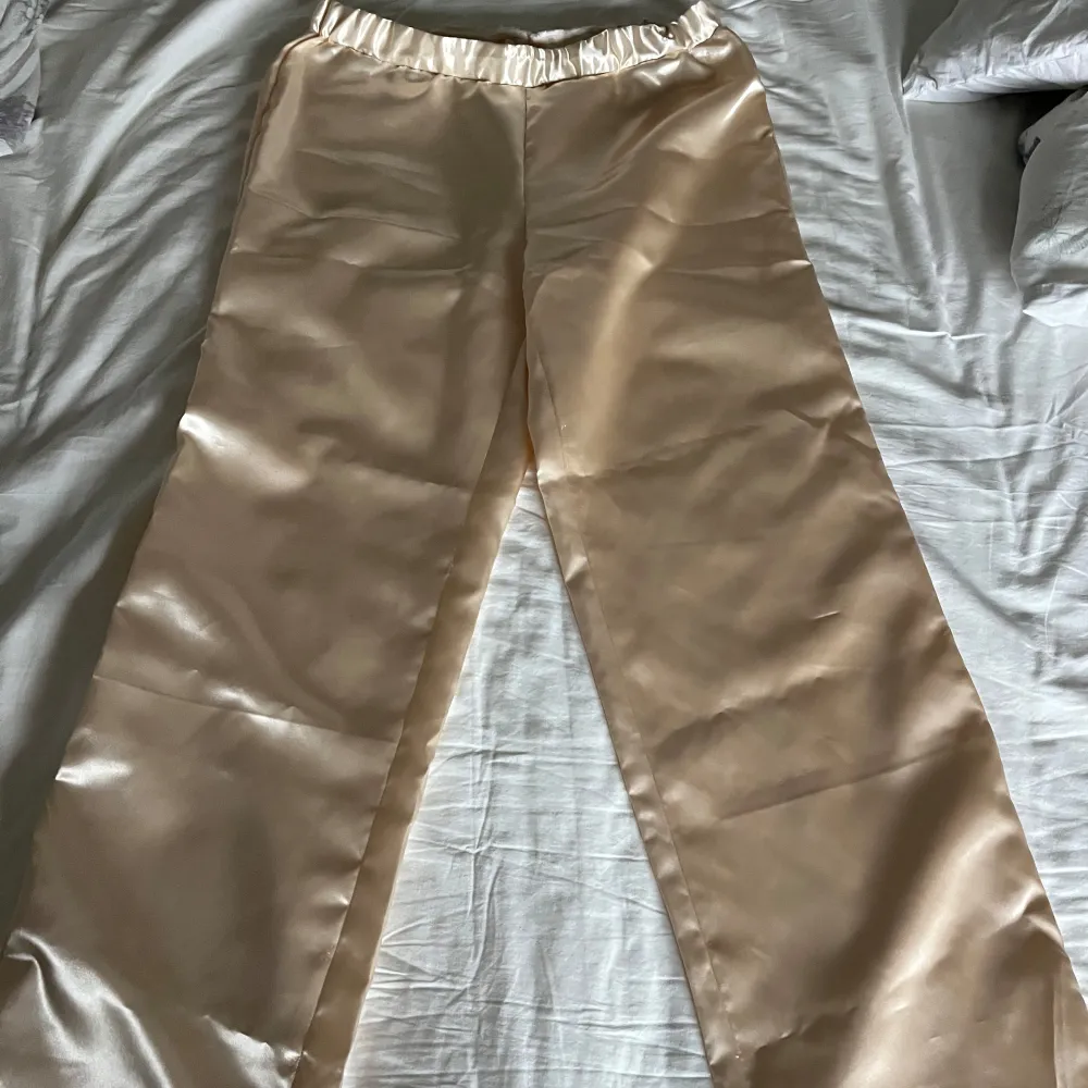 Säljer min satin pyjamas som jag sytt själv. De är low waisted med elastisk midja och loose/botcut nertill. Måtten är sydda utifrån mig (höft 98, midja 80, inneben 80). Jätte fina till mysiga morgonar eller en finare myskväll🥰kom dm för fler bilder eller frågor!💞. Jeans & Byxor.