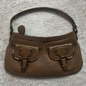 burberry väska - världens snyggaste burberry väska i nyskick! mjukt brunt läder med diskreta detaljer av det klassiska burberry mönsret. perfekt julklapp!