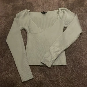 Grön ribbad topp från Lindex - Säljer en stilren grön ribbad topp från Lindex med v-ringning och långa ärmar. Perfekt för en chic och bekväm look. Passar utmärkt till både jeans och kjol.