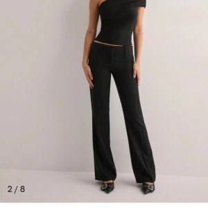 Svarta kostymbyxor - Svarta kostymbyxor low waist från Nelly. Storlek 32. Aldrig använda då de inte passar mig 