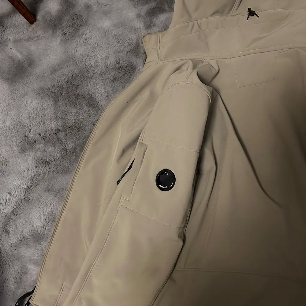 Säljer en snygg beige jacka från C.P. Company i storlek M. Jackan är tillverkad i C.P. Shell-R material, vilket är ett mjukt och stretchigt softshell-tyg av återvunnet garn. Den har en dragkedja framtill och praktiska fickor med dragkedjor. Perfekt för höst och vår! Nypris ligger den på 5576kr. Takit.