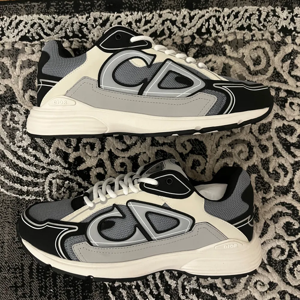 Säljer ett par splitter nya snygga Dior sneakers som är väldigt sällsynta. De har en cool design med stora CD-loggor på sidorna och är i ett helt nytt skick, aldrig använda. Perfekta för både vardag och fest! Skorna har snörning och en bekväm sula. Påse och snören tillkommer. Hör av dig vid frågor eller funderingar. . Skor.