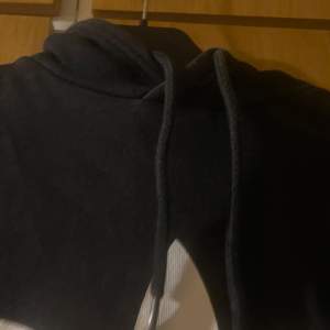 Säljer en svart hoodie från Adidas i mycket bra skick. Den har en stor vit logga på framsidan och en praktisk magficka. Perfekt för höst och vinter, och den är supermysig att ha på sig. Passar både till vardags och träning!