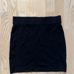 Svart kjol från Bik Bok - Snygg svart kjol från Bik Bok i storlek S. Den har en enkel och stilren design med en elastisk midja för en bekväm passform. Perfekt för både vardag och festliga tillfällen!
