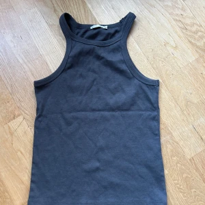 Mörkgrå ribbad topp NLY Trend - Säljer en snygg mörkgrå ribbad linnetopp från NLY Trend i storlek XS. Perfekt som ett basplagg i garderoben. Tight passform och är tillverkad i ett mjukt och stretchigt material. Endast använd en gång så i superbra skick! 🩶