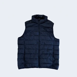 Mörkblå dunväst från Uniqlo - Säljer en snygg och lätt mörkblå dunväst från Uniqlo. Är mycket bra skick. 