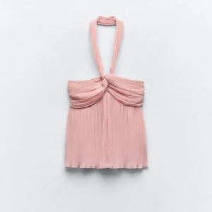 Rosa halterneck topp - Säljer en superfin rosa halterneck topp från Zara Den har en draperad design och ett lätt och bekvämt material. Den har aldrig kommit till användning, utan är endast bara provad.