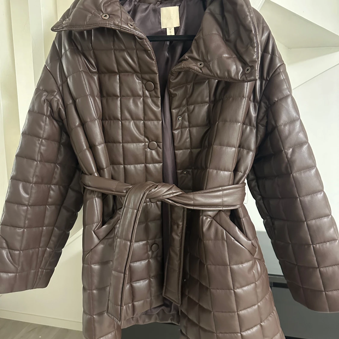 Brun quiltad kappa med bälte