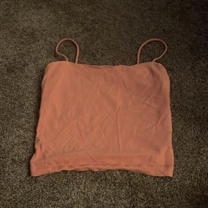 Rosa linnetopp från Gina Tricot - Säljer en söt rosa linnetopp från Gina Tricot i storlek XS. Toppen har smala axelband och är perfekt för sommardagar. Materialet är mjukt och bekvämt, vilket gör den idealisk för både vardag och fest. Passar perfekt till jeans eller kjol!🩷