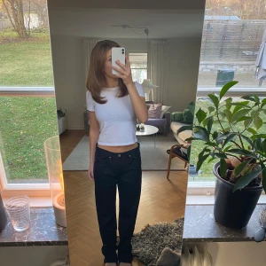 Svarta jeans  - Säljer ett par stilrena svarta jeans, i lite tunnare och glansigare material, i bra skick. De har lösare passform med mellanhög midja. Passar perfekt till en enkel t-shirt eller en mer uppklädd topp. I storlek 28/32!🖤