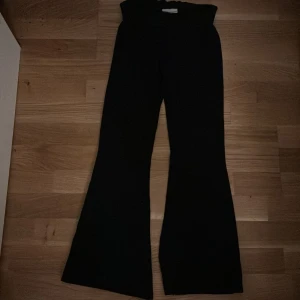 Svarta byxor med bootcut - Säljer ett par svarta byxor i bootcut-stil. De är högmidjade och har en snygg passform som passar perfekt till både vardag och fest. Materialet är mjukt och bekvämt, vilket gör dem sköna att bära hela dagen. Perfekta för höst och vinter! Också low waisted