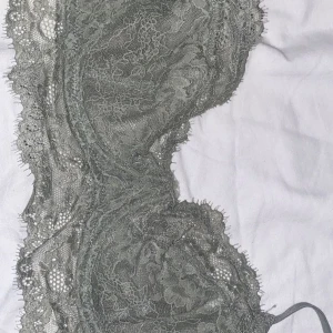 Grå spets-bh från H&M - Säljer en elegant grå spets-bh från H&M i storlek 75B. Den har vackra spetsdetaljer och en bekväm passform. Perfekt för både vardag och speciella tillfällen. Materialet är mjukt och stretchigt för extra komfort.