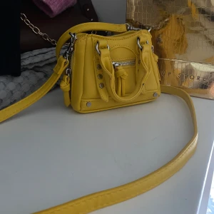 Gul axelväska med dragkedja - Säljer en superfin liten gul axelväska, nypris 199kr
