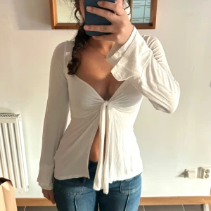 Vit långärmad topp med knyt - Säljer en superfin och populär topp från Design By Si. Den är perfekt för både vardag och fest. Passar perfekt till jeans eller kjol! Nypris 400kr, min pris 300kr❤️
