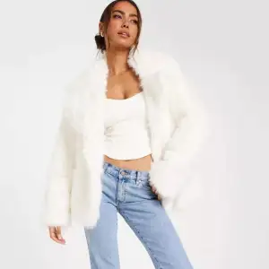 Vinterjacka, vit fluffjacka, furcoat(fauxfur)från Nelly. Syntetpäls(ej äkta päls). Aldrig använd så i nyskick. Storlek XS men oversized. Samma storlek som den modellen bär.