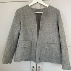Grå kappa - Säljer en stilren grå kavaj/kappa i ullmaterial som sitter superfint på med söta fickor! I storlek S från Massimo dutti. Postar endast🩷