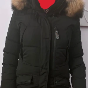 Vinterjacka från Hollies - Säljer en snygg jacka från hollies med äkta päls på huvan. Jackan har en dragkedja framtill och flera praktiska fickor. Den är i storlek 42 men är mer som M/L