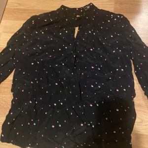 Blus från Sinéquanone - Jätte fin svart blus men prickar av olika färger! Jätte bra för vanlig dag och för när man ska klä upp sig. Jätte skönt material. Stod inte storlek men gissar på M.