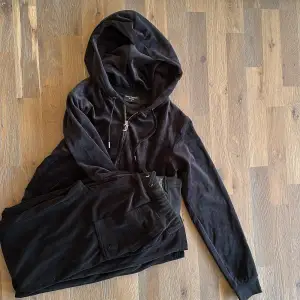 Säljer en supermjuk och bekväm svart velour hoodie från Juicy Couture. Perfekt för en avslappnad dag eller mysiga stunder hemma. Den har en dragkedja framtill och justerbar huva med snören. Passar perfekt till höst och vinter! Hoodien är liten i storlek 🖤