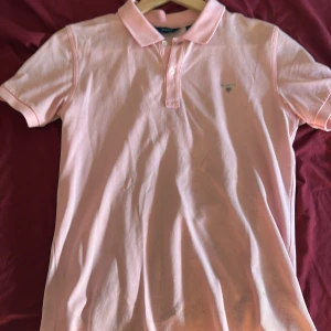 Rosa pikétröja från GANT - Säljer en snygg rosa pikétröja från GANT i bra skick. Den har en klassisk krage och knappar framtill. Perfekt för både vardag och lite finare tillfällen. Passar perfekt till sommaren! 💖pris kan diskuteras 