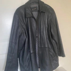 Svart skinnjacka från Janbell - Säljer en snygg vintage skinnjacka från Janbell i bra skick. Jackan har en dragkedja framtill och långa ärmar. Perfekt för höst och vår, med en klassisk stil som funkar till det mesta. Passar både till vardags och fest!