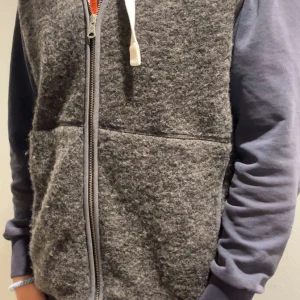 Grå ullväst från J.Lindeberg - Säljer en stilren grå ullväst från J.Lindeberg. Västen har en praktisk dragkedja framtill och är perfekt för lager-på-lager under kyliga dagar. Den har en normal passform och är i mycket bra skick. Perfekt för höst och vinter!                     Priset är diskuterbart!😀