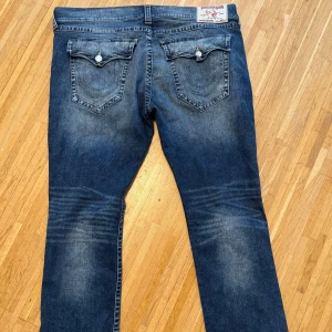 Blå jeans från True Religion - Säljer ett par snygga blå jeans från True Religion i storlek 42. 