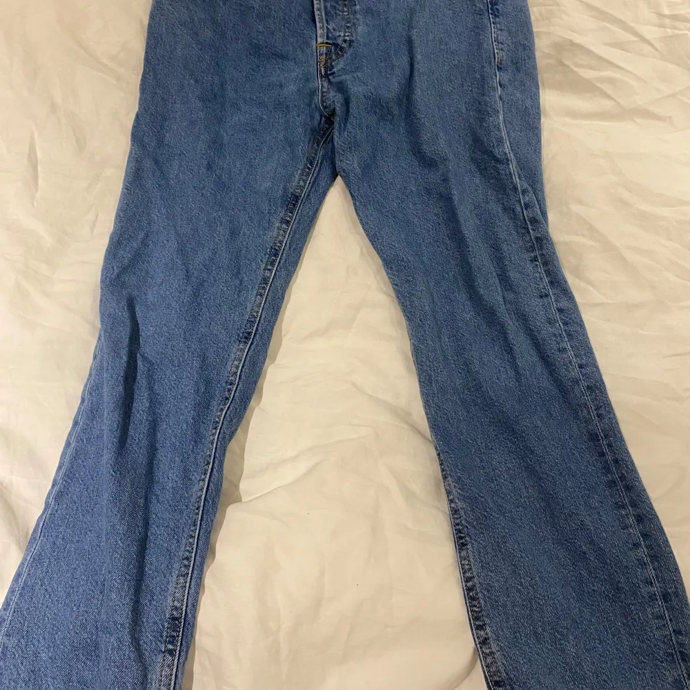 Säljer ett par klassiska blå jeans från Jack & Jones i mycket bra skick. De har en straight passform och är perfekta för vardagsbruk. Jeansen har en traditionell design med fem fickor och knappgylf. Perfekta för både höst och vår! Modellen på bilden är 166 cm lång.. Jeans & Byxor.