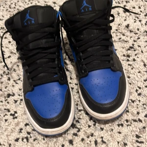 Nike Air Jordans i svart och blått - Säljer ett par Nike Air Jordans i svart och blått. Skorna har en klassisk design med snörning och är i bra skick. Perfekta för både vardag och fest! 🏀