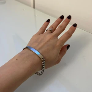 Äkta silver 925armband med kedja - Säljer ett stilrent äkta silver 925armband med en platt bricka och robust kedja. Perfekt för både vardag och fest! Armbandet har en säker låsning och är i mycket bra skick. Passar perfekt som en subtil men elegant accessoar.