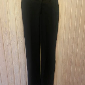 Svarta kostymbyxor från Lindex - Snygga svarta kostymbyxor från Lindex i storlek 34. De har en klassisk och stilren design med raka ben och diskreta fickor. Perfekta för både kontoret och festligare tillfällen. Tillverkade i ett bekvämt material som ger en elegant look.