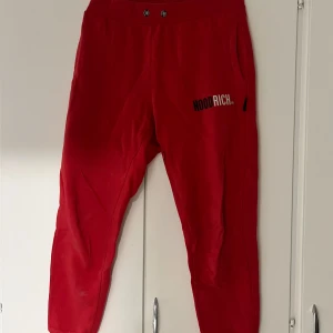 Röda mjukisbyxor från Hoodrich - Säljer ett par snygga röda mjukisbyxor från Hoodrich. Det är perfekta för både chill och vardag. Byxorna har en elastisk midja och två sidofickor. Hoodrich-loggan är tryckt på ena benet. Perfekta för höst och vinter!