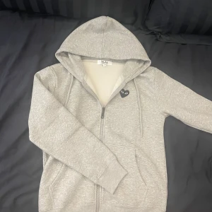 Cdg Zip-Hoodie  - Cdg full zip i riktigt bra skick. | Den är gjord av bomull och polyester. Så den är väldigt skön och mysig att ha på sig🤗. | Det är bara att höra av sig om man har några frågor eller vill ha flera bilder🔥🔥🔥