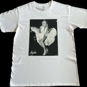 Monroe T-shirt  - Lagerrensar kläde från Jayhu Sweden. Här är en  vit t-shirt med motiv på ikoniska Marilyn Monroe. Helt inplastat och nyskick ✅